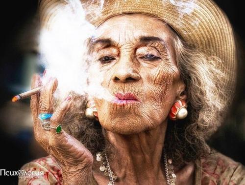 Женщина лет 80 в платье под Зебру, с крупными серьгами в ушах и ярким алым маникюром разговаривает по телефону у входа в буланжери: